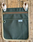 Green pouch with beige accents on a wooden surface, featuring the 'Artifact' brand label.
