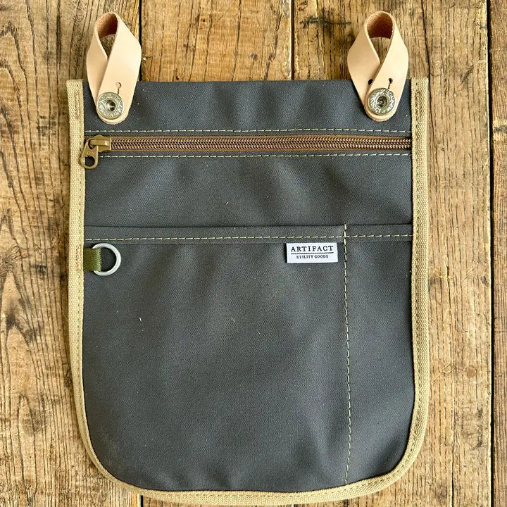 Gray organizer bag with beige accents on a wooden surface