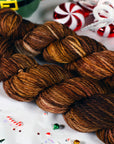 Brown yarn skeins on a festive background with candy canes and Christmas decorations.