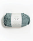 Ball of sage blue yarn with a label on a white background