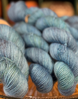 Blue skeins of yarn on a glass plate with a blurred background