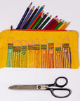 Yellow pencil case with colorful embroidered designs and pencils, accompanied by a pair of scissors on a white background.