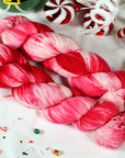 Red and pink yarn skeins on a white background with candy-themed decorations