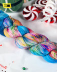 Colorful sock weight skein of yarn with candy-themed background
