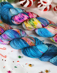Colorful skeins of yarn on a festive background with candy canes and Christmas decorations.