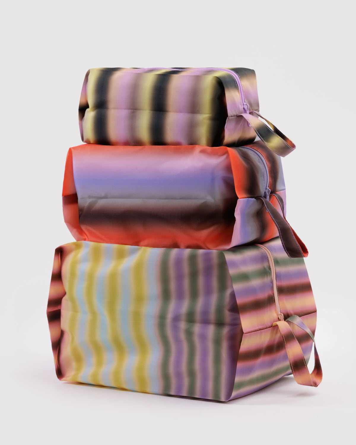 Stack of colorful striped fabric boxes on a white background