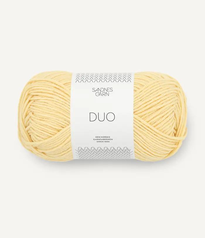 Ball of yellow yarn with a white label on a light gray background
