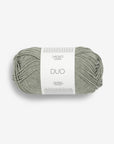 Ball of light sage green yarn with a label on a white background