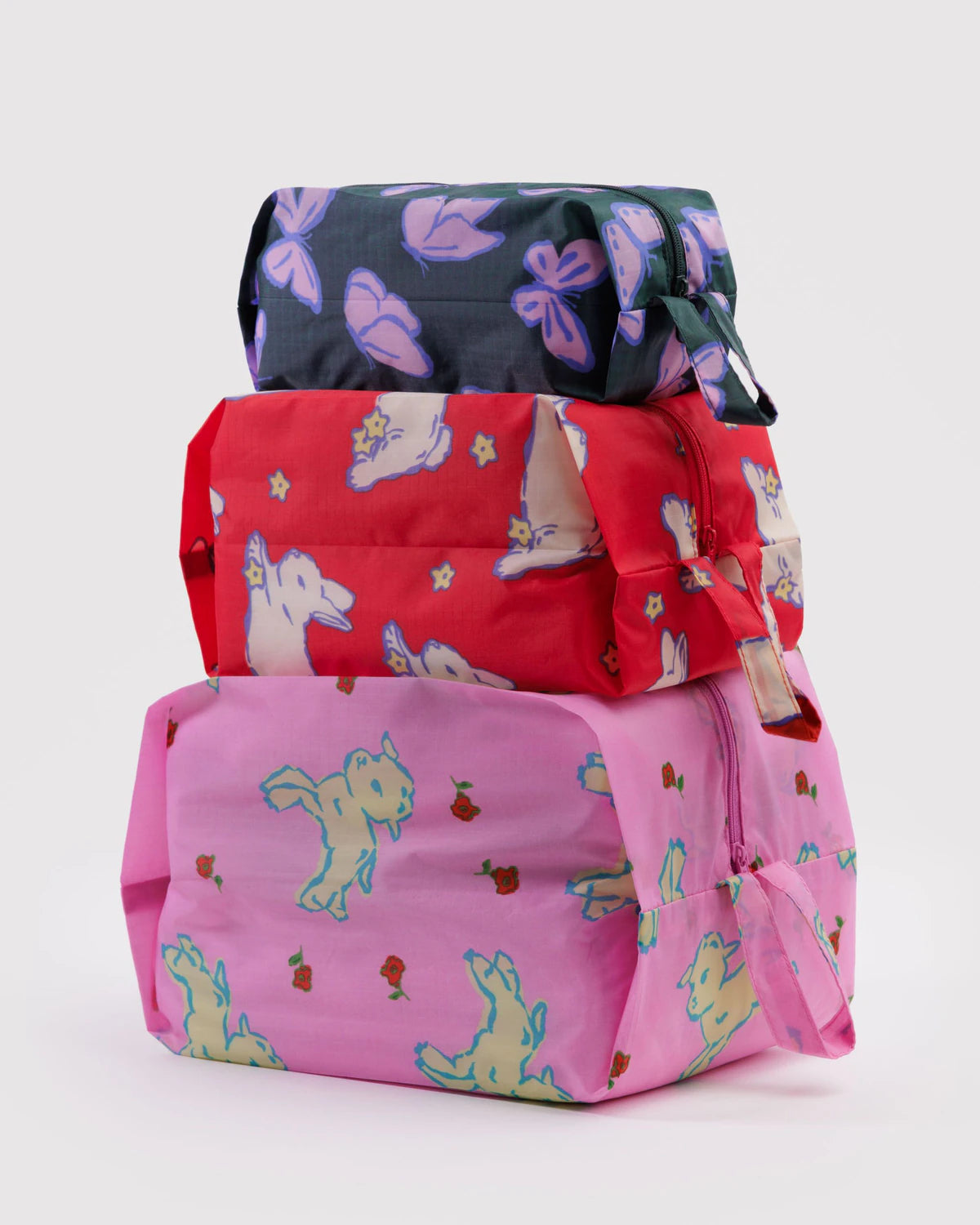 Three colorful bags with lambs, bunnies and butterflies stacked on a white background