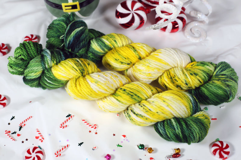 Colorful yarn skeins on a festive background with candy canes and peppermints.
