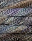 Close-up of multicolored yarn skeins with light blues, beige, lavender and grey.
