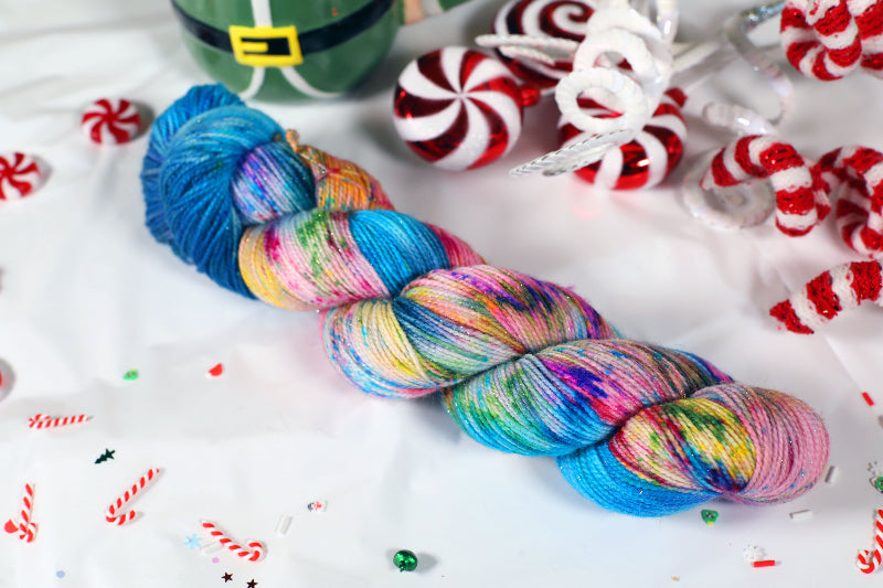 Colorful sock weight skein of yarn with candy-themed background