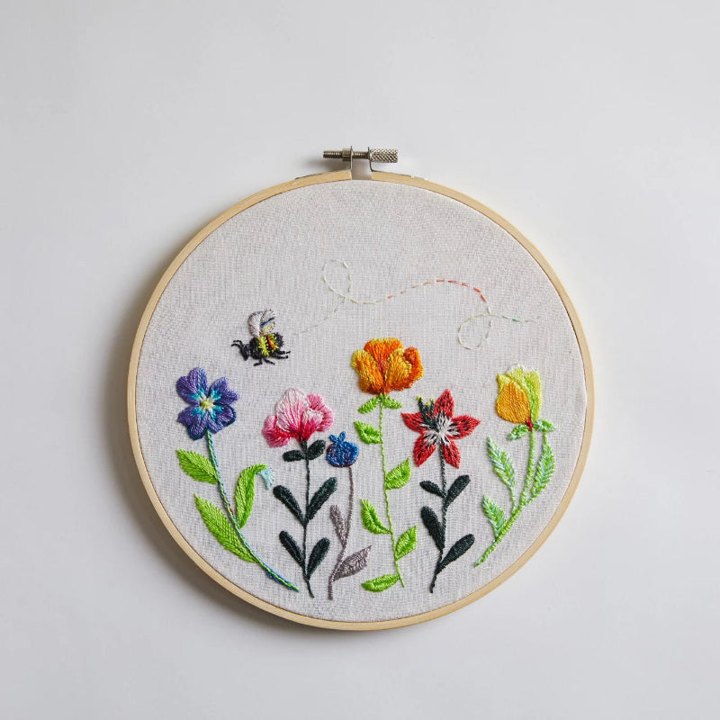 Embroidery hoop with colorful floral design on a whte background