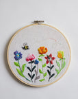 Embroidery hoop with colorful floral design on a whte background