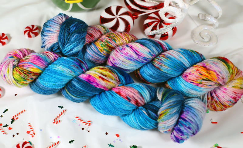 Colorful worsted weight skein of yarn on a decorative background with candy canes