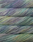 Close-up of multicolored yarn skeins with a gradient of pale colors including blue, green, and purple.