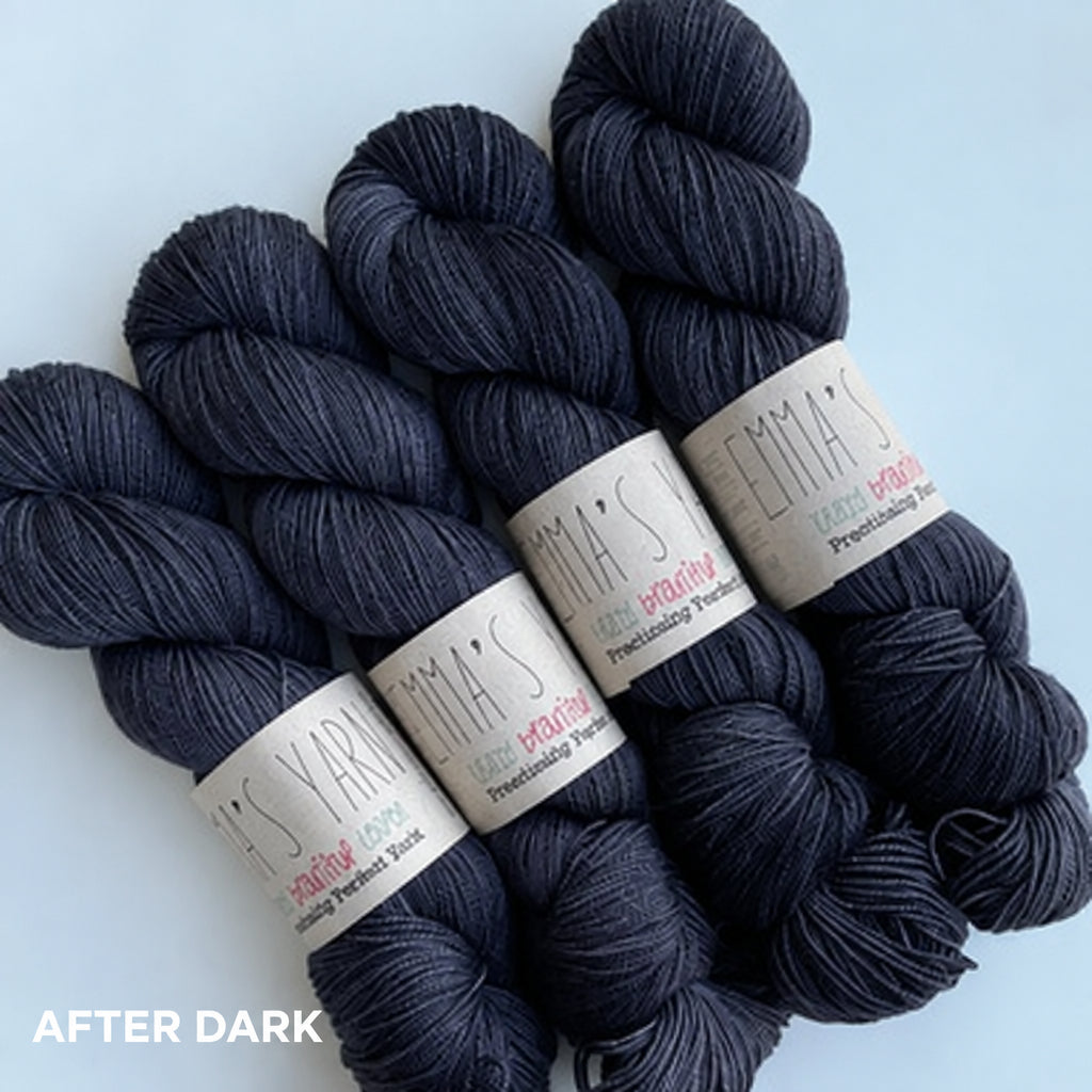A collection of very dark purple mini skeins of yarn arranged together.