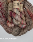 Three skeins of taupe with deep red multicolored yarn with labels on a white background