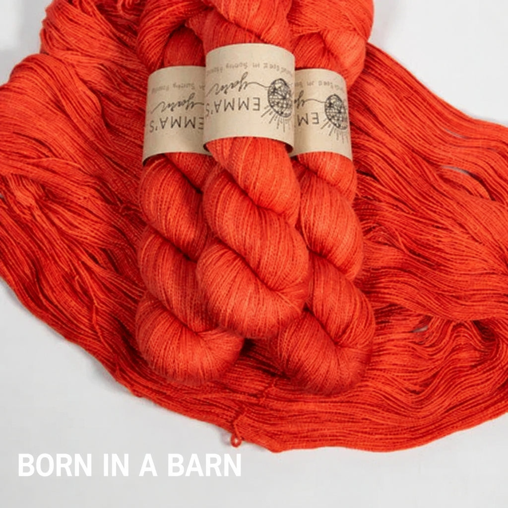 Two skeins of bright tomato red yarn with labels on a white background