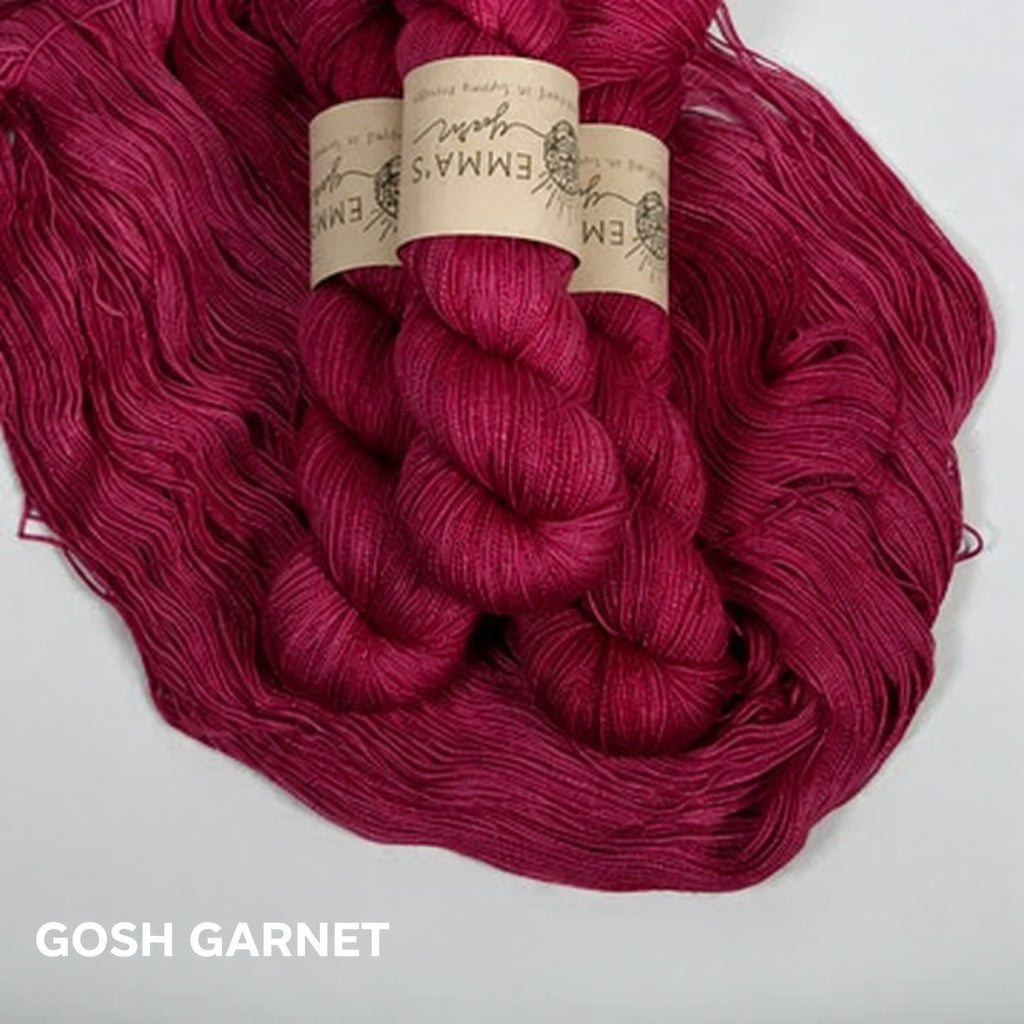 Balls of garnet colored yarn with labels on a white background
